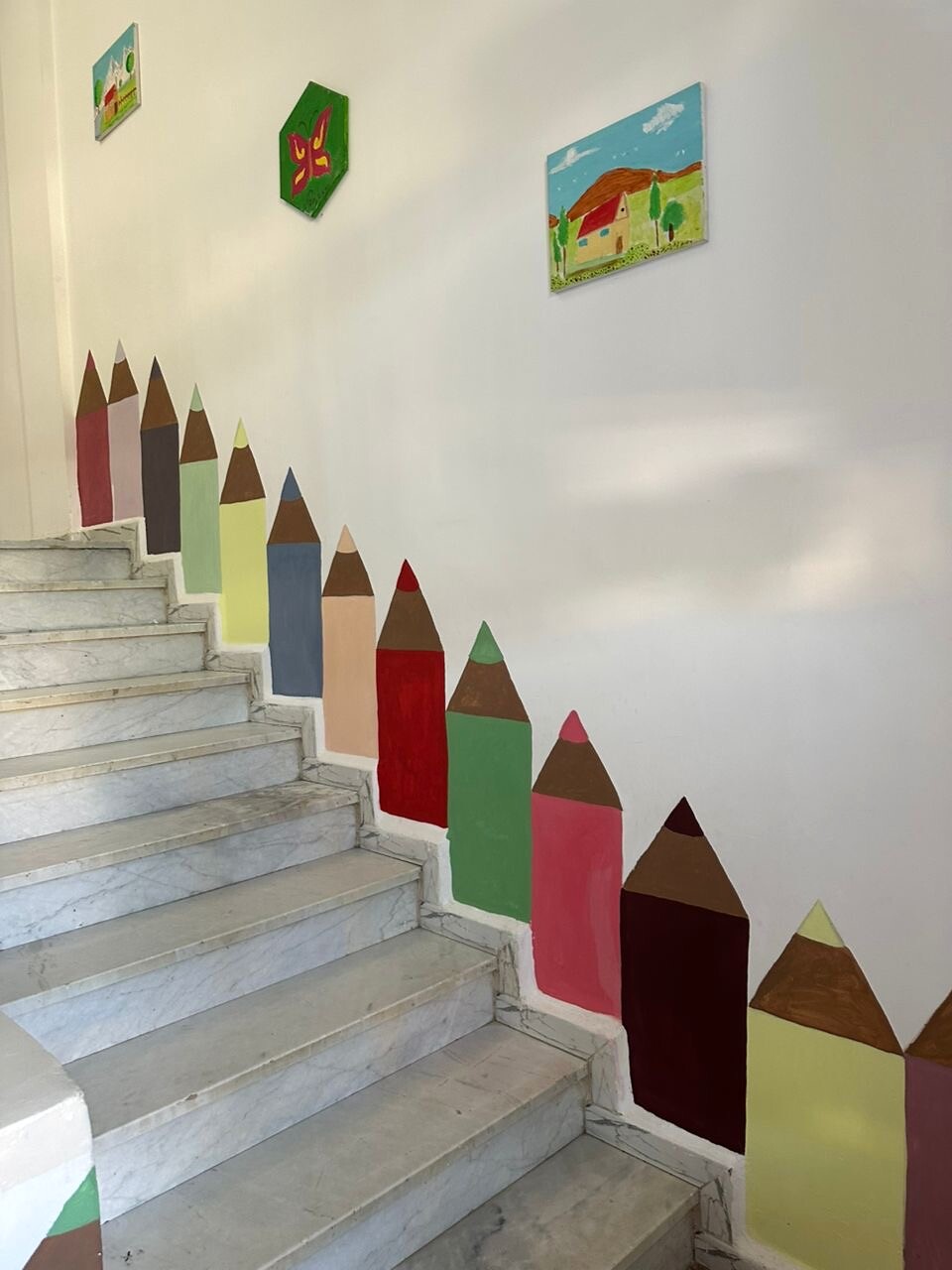 Escalier lumineux décoré de grands crayons colorés